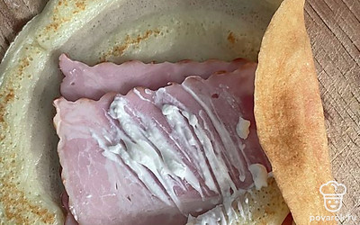 Смажьте грудинку творожным сыром.