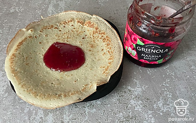 Выложите блин на тарелку. Положите в середину любимое варенье. Количество начинки зависит от ваших предпочтений.