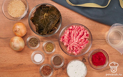 Лук почистите, измельчите на терке или в блендере. Обдайте виноградные листья кипятком. Осторожно отделите друг от друга, срежьте корешки. Отварите рис в подсоленной воде до полуготовности в течение 15 минут. Совет: листья темных сортов винограда резче на вкус и жестче, у светлых сортов вкус с нежной кислинкой и гибкие листья.