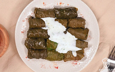 Подавайте виноградные голубцы с соусом из мацони с толченным чесноком.