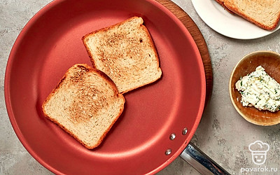 Сделайте начинку. В небольшой миске смешайте сливочный сыр и нарезанную зелень. Посолите, поперчите по вкусу. Возьмите сковороду, поставьте на огонь и выложите ломтики хлеба. Обжарьте с обеих сторон до румяной и хрустящей корочки.