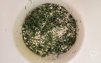 Натертый сыр поместите в небольшую миску. Очень мелко нарежьте укроп и добавьте его к сыру. Все хорошо перемешайте. У вареных листьев капусты обрежьте утолщения.