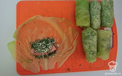 На лист капусты выложите сосиску, столовую ложку сыра с укропом и заверните конвертиком. Обжарьте все голубцы на среднем огне, под закрытой крышкой, на оливковом масле со всех сторон.