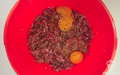 Лук мелко нарежьте. Смешайте говяжий фарш с измельченным луком, солью, перцем. Добавьте в фарш 2 яйца. Все тщательно перемешайте. Сыр натрите на крупной терке.
