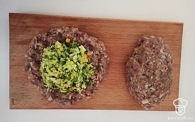 Возьмите около 2 столовых ложки фарша и сформируйте из него лепешку. Выложите в середину 1 столовую ложку начинки и соедините края фарша. Немного покатайте голубец в руках, чтоб получилась форма котлеты. Таким образом сделайте голубцы из всего фарша.