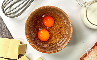 Приготовьте льезон. В небольшую миску разбейте яйца и влейте молоко. Взбейте до однородности. Возьмите по два ломтика хлеба и между ними уложите белый шоколад. Сформированные тосты аккуратно обмакните с двух сторон в яичную смесь.