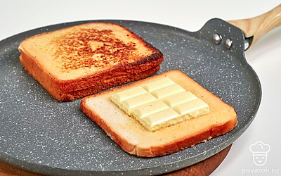 Обжарьте тосты. Сковороду поставьте на огонь, раскалите и отправьте в нее сливочное масло. Растопите масло, выложите тосты. Поджарьте с одной стороны в течение 2-3 минут, переверните и обжарьте столько же времени.