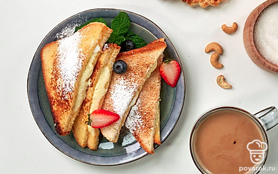 Тосты с белым шоколадом разрежьте по диагонали и посыпьте сахарной пудрой.