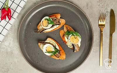 Тост с солеными огурцами перед подачей оформите зеленью укропа.