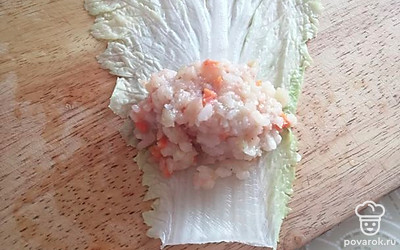 С листьев капусты срезать толстую часть, опустить их в кипящую подсоленную воду, затем обсушить. На готовые листья выложить фарш и свернуть конвертиками. 