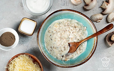 Приготовьте начинку. Шампиньоны и куриное филе мелко порежьте. На сковороде растопите сливочное масло, обжарьте курицу с грибами в течение 10 минут, регулярно помешивая. Сыр натрите на терке. Когда курица остынет, смешайте ее с сыром, сметаной, солью и черным молотым перцем.