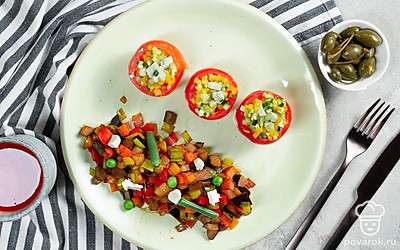 Подайте фаршированные овощами помидоры, украсив их колечками маслин.