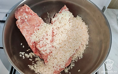 В мясной фарш добавьте промытый сырой рис. Посолите и перемешайте.