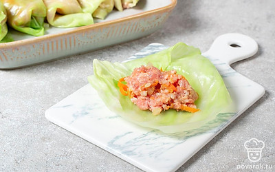 В каждый капустный лист положите 1-2 столовые ложки начинки. Подверните лист снизу, потом по бокам. Плотно скрутите в рулет. Уложите плотно голубцы в форму для запекания швом вниз.