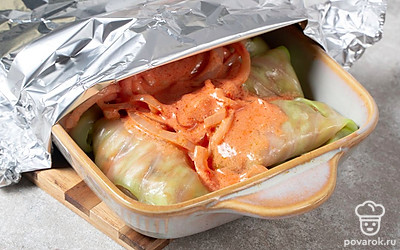 Выложите соус на голубцы. Плотно накройте форму для запекания фольгой. Отправьте в духовку на 30 минут. Потом снимите фольгу и запекайте еще 30 минут