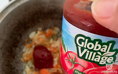 В казане обжарить овощи и добавить томатную пасту.