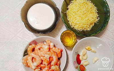 Промойте креветок и очистите креветок от панцирей. Отрежьте сыр и натрите на мелкой терке. Налейте сливки и подготовьте масло. Очистите чеснок от кожуры и нарежьте мелкими кусочками.