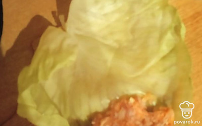 Раскрываем капустный лист, кладем в него фарш. Закручиваем. 