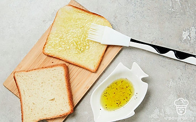 Подготовьте хлеб. Подсолнечное масло смешайте с чесноком, оставьте на 10 минут, чтобы масло пропиталось чесночным ароматом. Куски хлеба смажьте маслом с двух сторон при помощи кулинарной кисти.