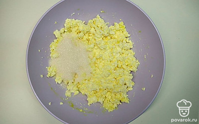 Возьмите отдельную тару и добавьте туда творог, затем помесите туда яйцо и смешайте. Далее добавьте в манку сахар и ванильный сахар. Размешайте все вместе.