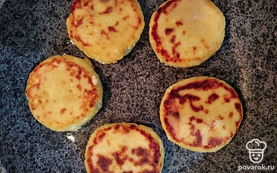 Поместите полученные сырники на сковородку. Начините их жарить на медленном огне до румяной корочки. Далее, разместите сырники в тарелочку.