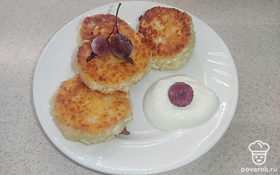 Подавайте сырники вместе с сметаной и ягодами.