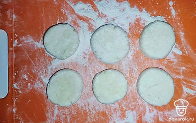 Достаньте полученное тесто из холодильника. Начните формировать круглые сырники, не забывая посыпать их мукой.