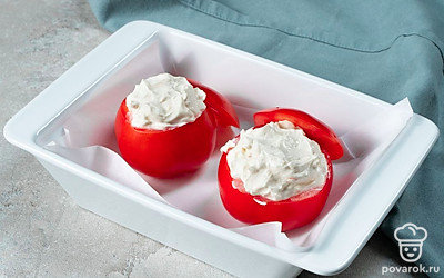 Запеките помидоры. Начинку распределите по помидорам, переложите на противень, застеленный пергаментом, отправьте в духовку на 20 минут.