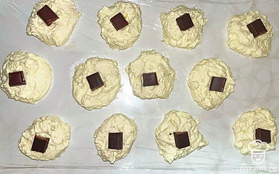 Из получившейся массы сформируйте кружочки, раскатайте их и сформируйте их и немного приплюсните, в каждый поместите квадратик шоколада.
