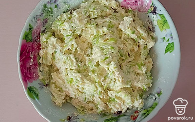 К творогу добавьте соль, сахар и яйцо, затем все перемешайте. Добавьте манку, перемешайте и дайте постоять минут 10. Кабачок почистите и натрите на терке. Посолите, затем хорошо отожмите. Добавьте к творогу кабачок и муку. Перемешайте.