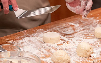 Сформируйте колбаску из массы на доске, припыленной кукурузным крахмалом, нарежьте колбаску на 4–5 толстых сырника и обваляйте их полностью в крахмале.