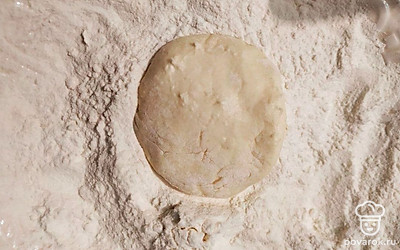 В тарелку насыпьте немного муки. Сформируйте из творожной массы шарики, немного придавите их, чтобы они приплюснулись. Обваляйте в муке.