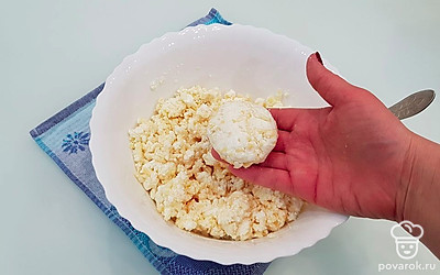 Возьмите часть теста, скатайте шарик и приплюсните его между рук, формируя сырник.