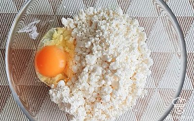 Положите творог в глубокую миску, добавьте яйцо, перемешайте.