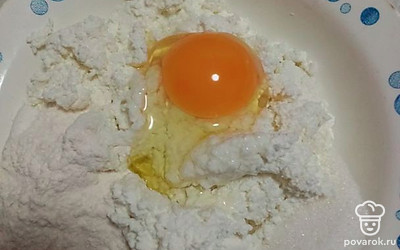 Добавьте яйцо, сахар и 2 столовые ложки муки. Размешайте все ингредиенты до однородной массы.