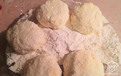 Слепите шарики и чуть примните их для получения формы сырника. Обваляйте их в муке.