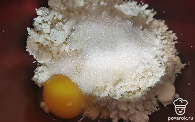 Творог разомните вилкой. Добавьте 1 яйцо и весь сахар. Смешайте с творогом. Добавьте пару ложек муки. Остальная мука останется для формирования сырника с обеих сторон.