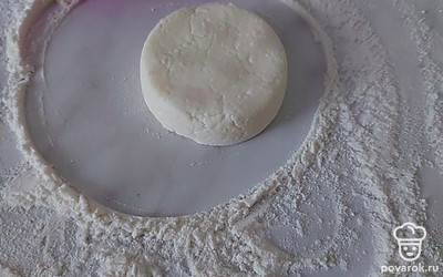 Дальше я поделюсь с вами лайфхаком для идеальной формы сырников: присыпьте стол мукой, выложите ложку нашего теста на стол, накройте его стаканом и крутите стакан по кругу. Ваш идеальный шарик готов, осталось приплющить его донышком стакана или рукой.