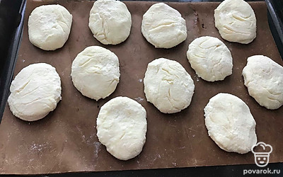 Разделить тесто на 11-12 частей, скатать шарики, приплюснуть и отправить на противень. В разогретой до 180 градусов духовке выпекать сырники по 10-15 мин с каждой стороны.