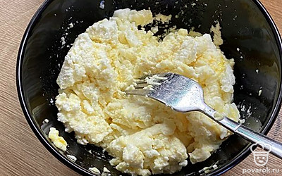 Добавьте в творог яйцо и перемешайте вилкой. Добавьте сахар.