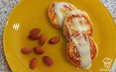 Подавайте порционно. Полейте сырники сгущенным молоком и украсьте орехами.