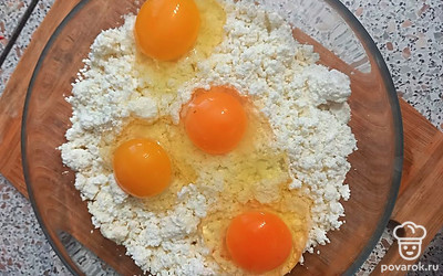 Добавьте в творог яйца, перемешайте до получения однородной массы. На каждые 200 г творога нужно одно яйцо.