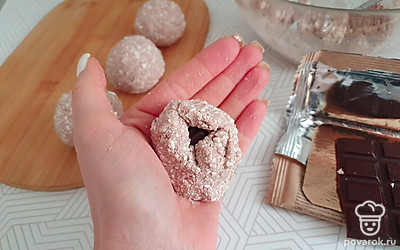 Плитку шоколада ломаем на кусочки. Берём часть теста, делаем лепёшку, кладём внутрь кусочек шоколада и аккуратно закрываем края, делая круглый сырник. 