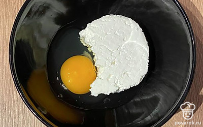 Положите творог в миску и добавьте в него яйцо.