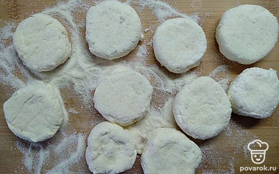 При помощи лопатки придать сырникам форму. Обвалять сырники со всех сторон и оставить на 5 минут.