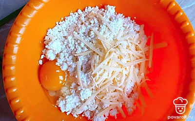 Сыр натереть на крупной терке и высыпать в творог.