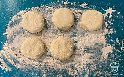 Посыпать мукой поверхность (1 столовой ложкой). Сформировать сырники руками.