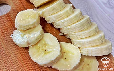Когда сырники приготовятся, приступаем к жарке банана. Необходимо его почистить и порезать. 