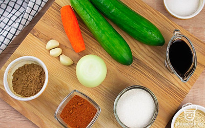 Помойте огурцы. Почистите морковь, лук и чеснок.