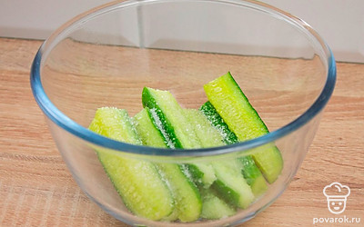 Положите огурцы в глубокую миску, присыпьте солью и оставьте на 10-15 минут.